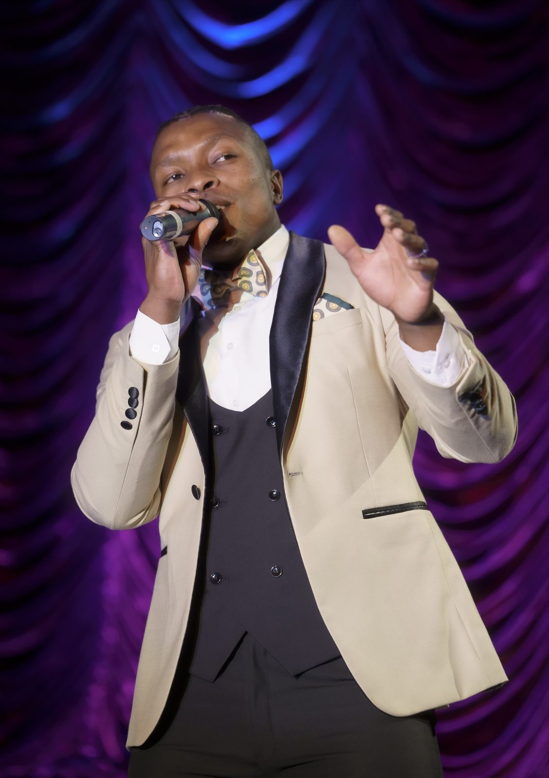 Thuba Myeki singing under stage lights
